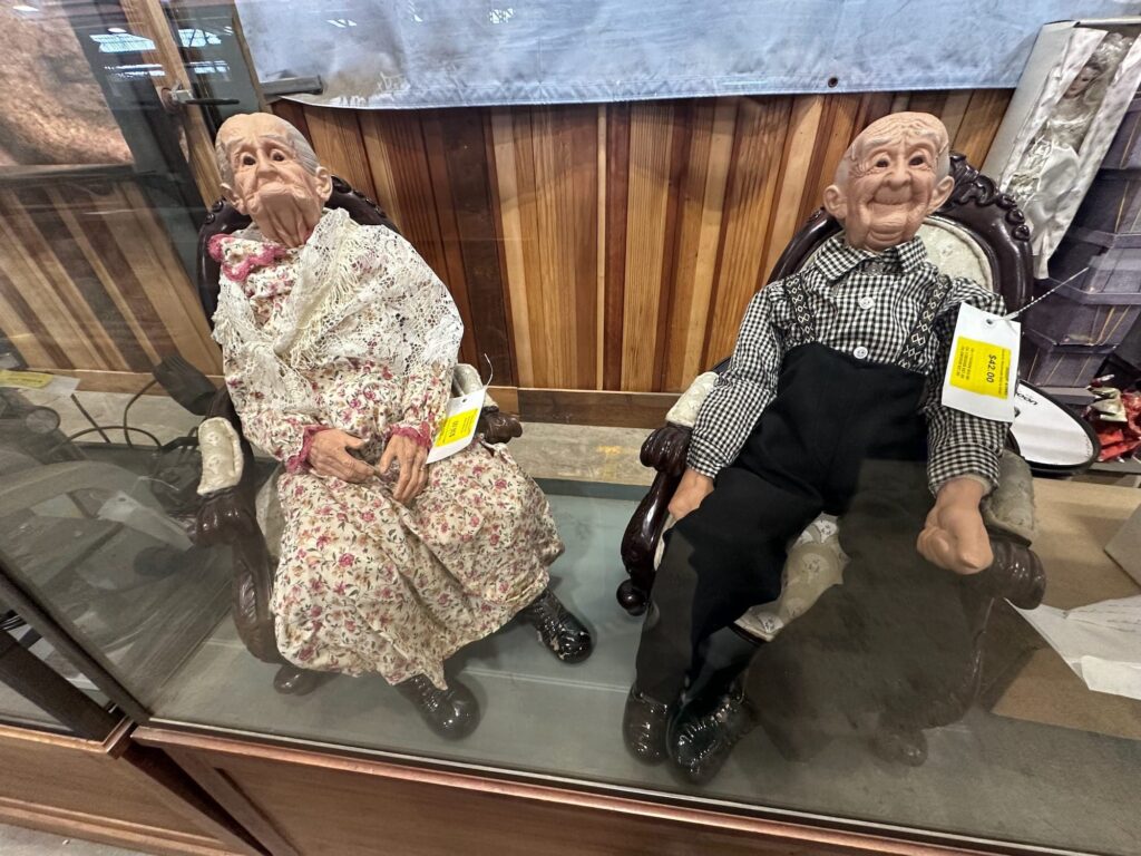 Two vintage dolls depicting two elderly people in rocking chairs, one of many unique finds at Second Chance Inc.'s massive warehouse in South Baltimore.